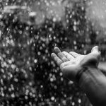 Hand held out into the rain